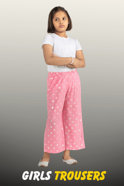 A young girl wearing pink wide-leg trousers with white polka dots and a plain white t-shirt from Nazz Collections.